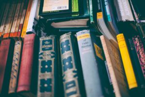 a messy pile of books with colourful spines