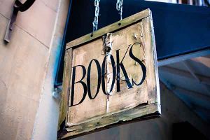 image of sign hanging from two chains reading "Books"