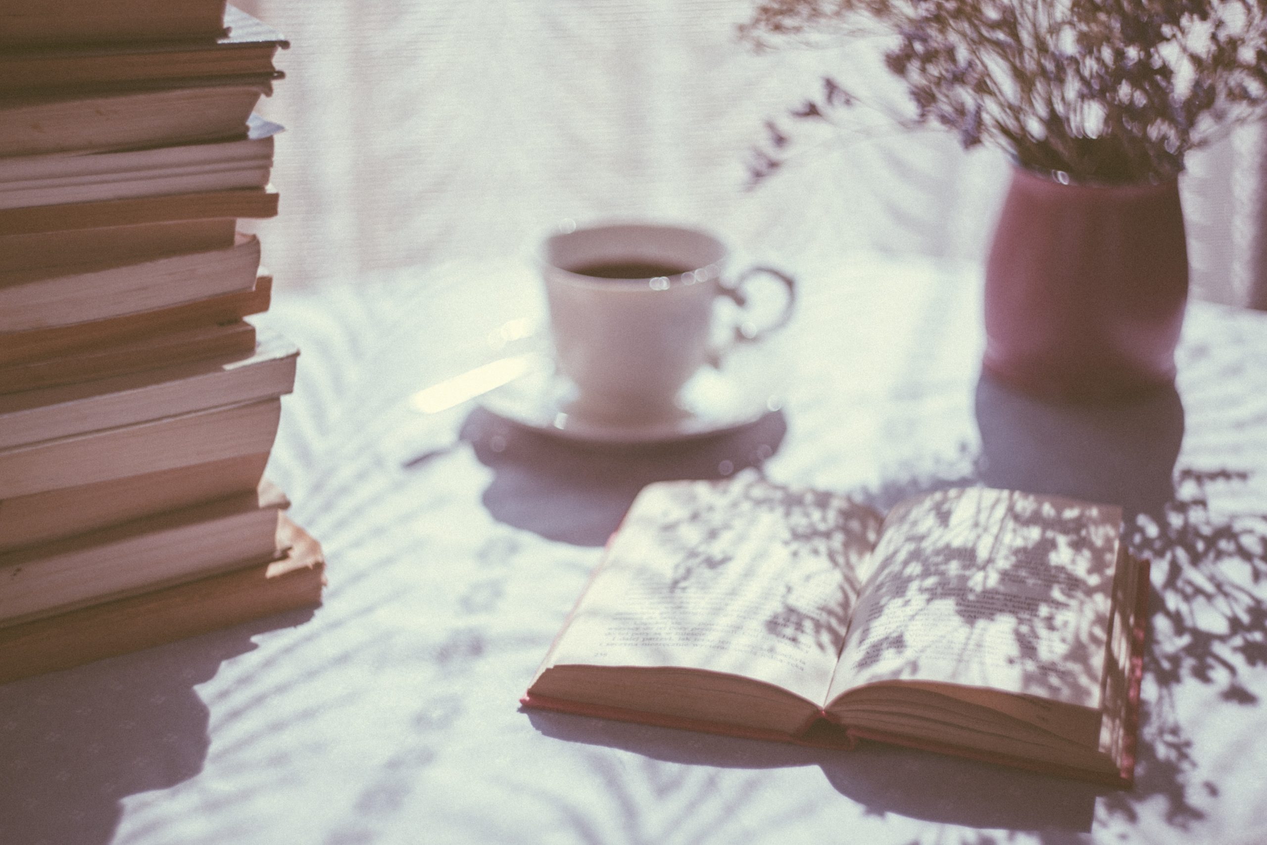 image of an open book and cup on a table